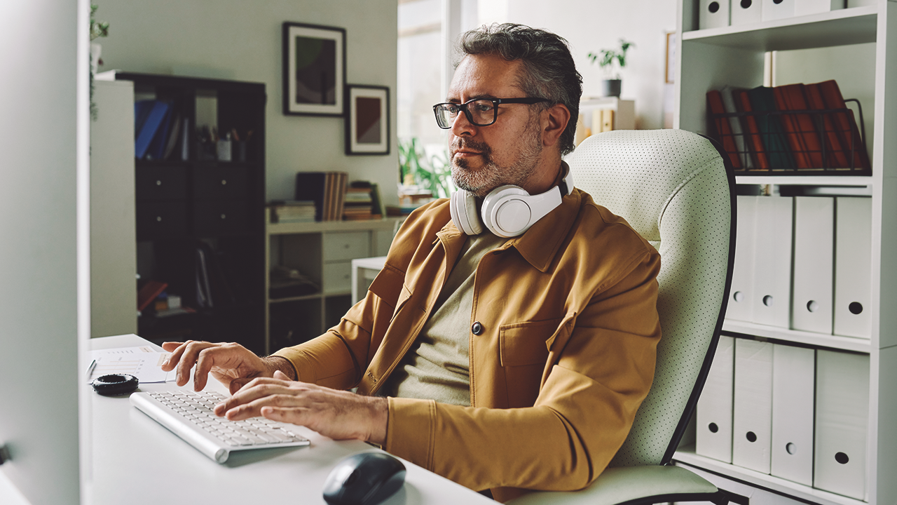 Man sitting in an office typing on a keyboard