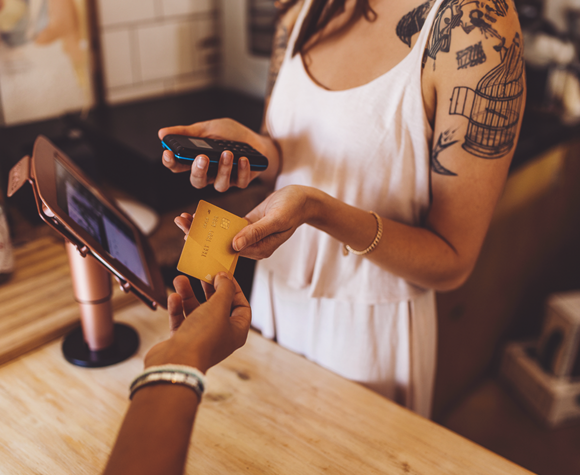 A person hands a card to a service employee to pay.