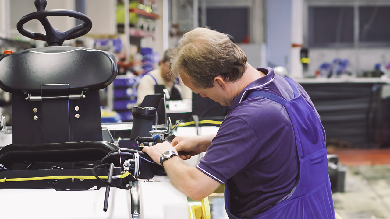 A man is working on a vehicle in a workshop.
