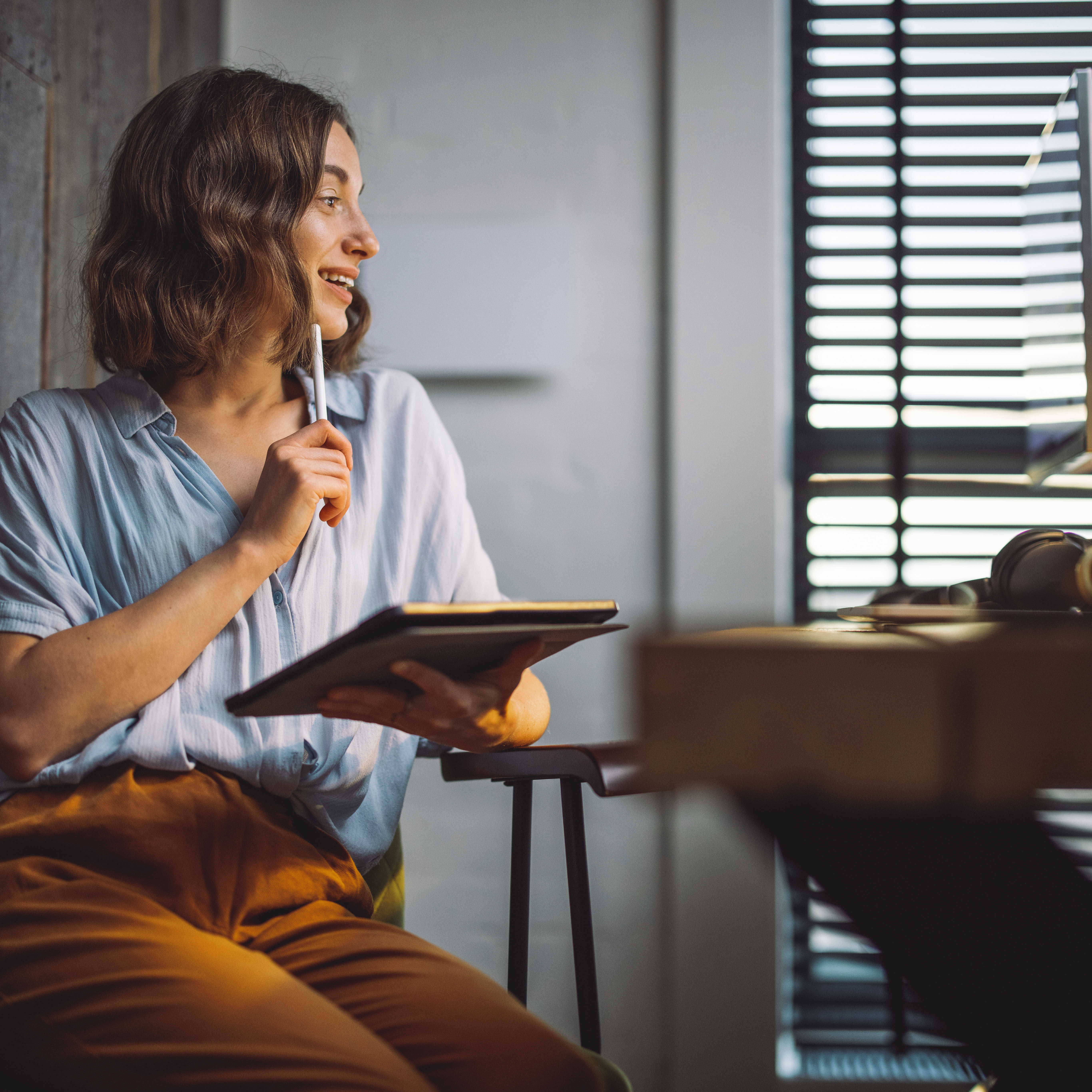 Smiling woman taking notes with a tablet during a training session