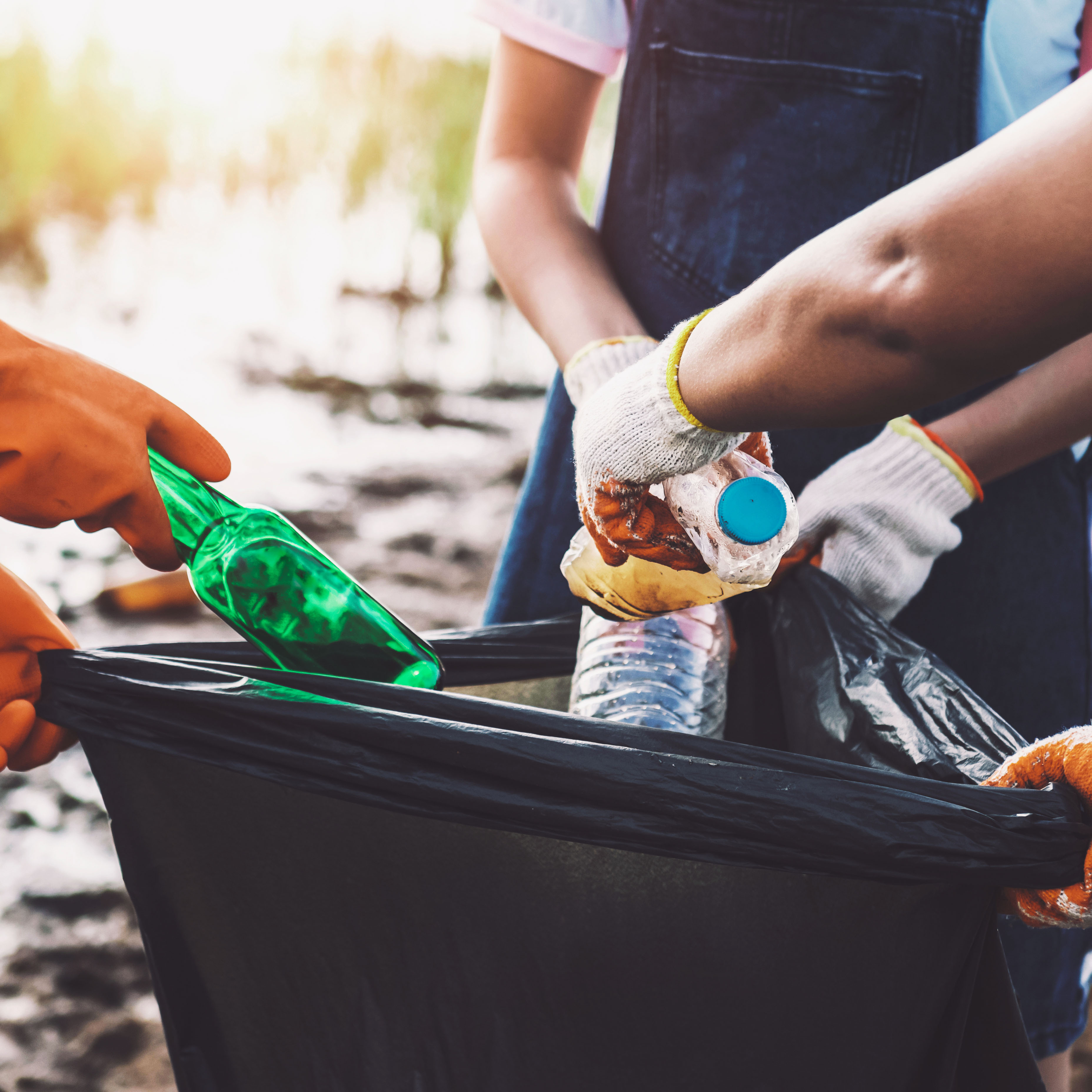 Nahaufnahme von drei Personen und deren Händen, die Flaschen tragen