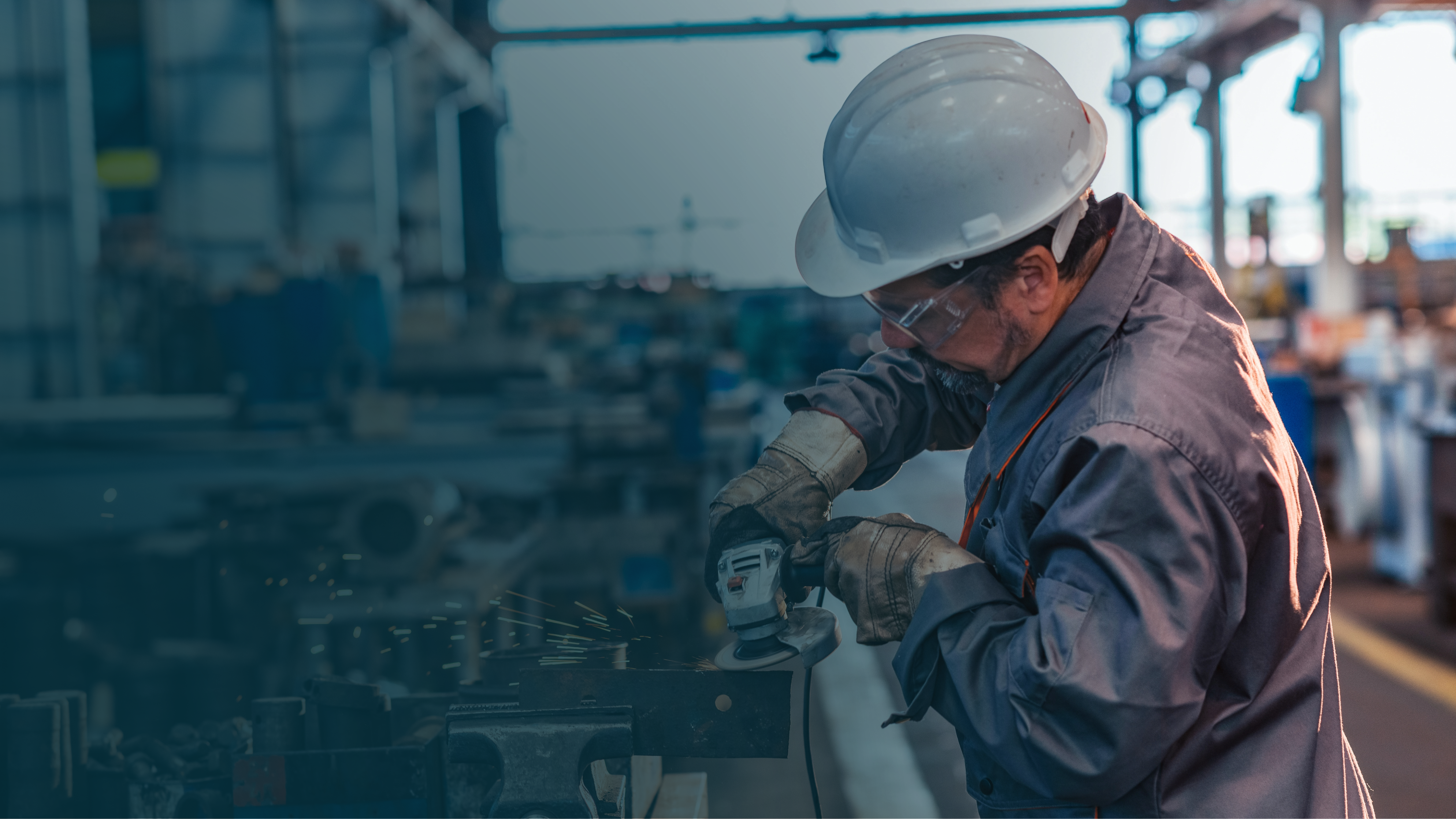 Mężczyzna w stroju ochronnym używający szlifierki kątowej.