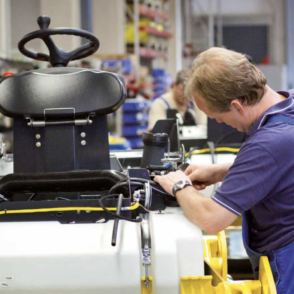 A man is working on a vehicle in a workshop.